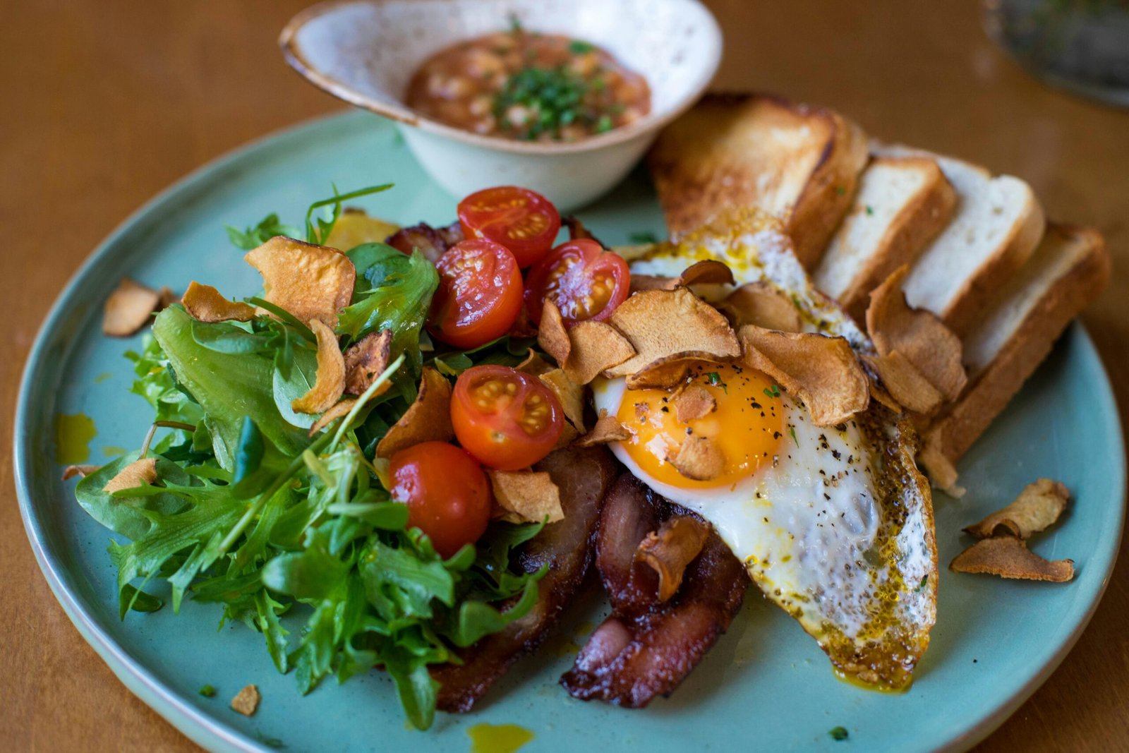 A mouth-watering breakfast featuring eggs, bacon, and fresh vegetables on a plate.